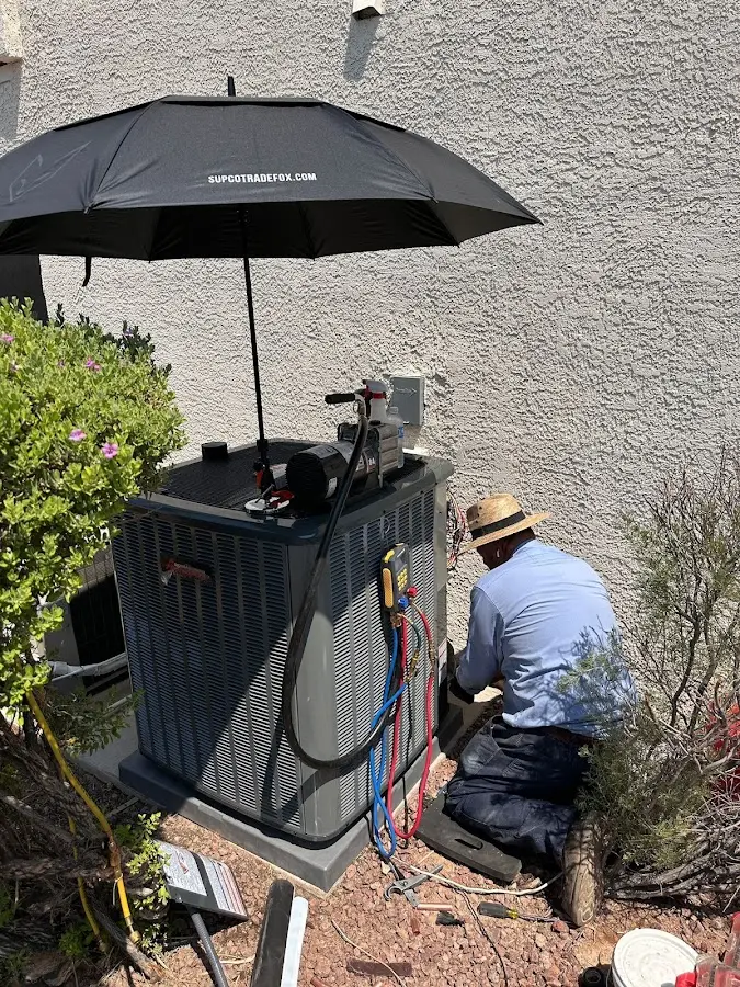 HVAC technician performing outdoor AC maintenance in Sheffield Lake