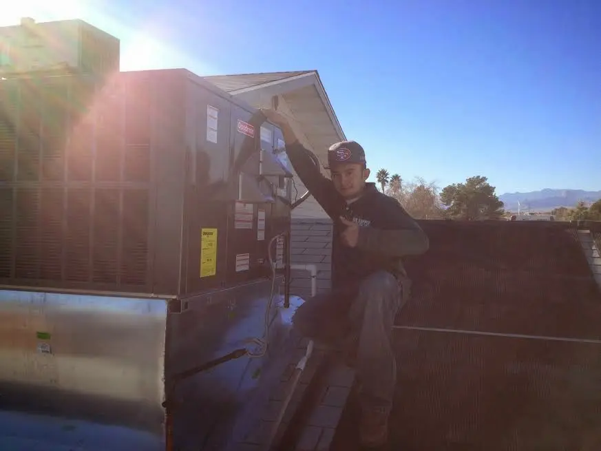 HVAC technician performing AC Tune-Up on a rooftop unit in Sheffield Lake